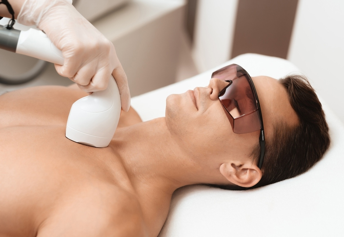 Dermatologist performing laser hair reduction treatment on patient